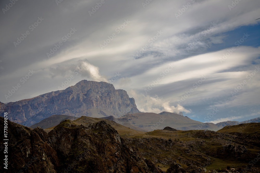 Горный пейзаж. Красивый вид на живописное ущелье, белые облака над высокими горами. Дикая природа Северного Кавказа
