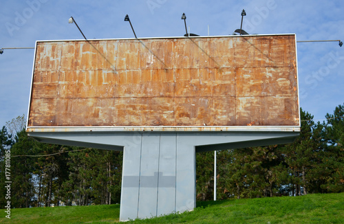 Old empty and rusty abandoned billboard and lights during sunny day