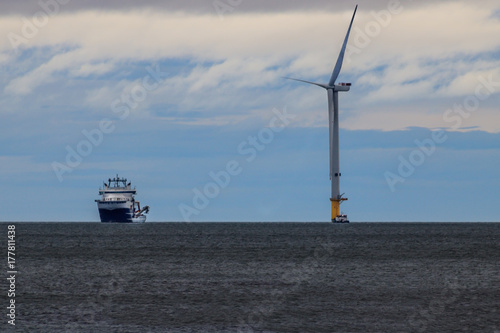 ship moored next to wind turbine in the north sea