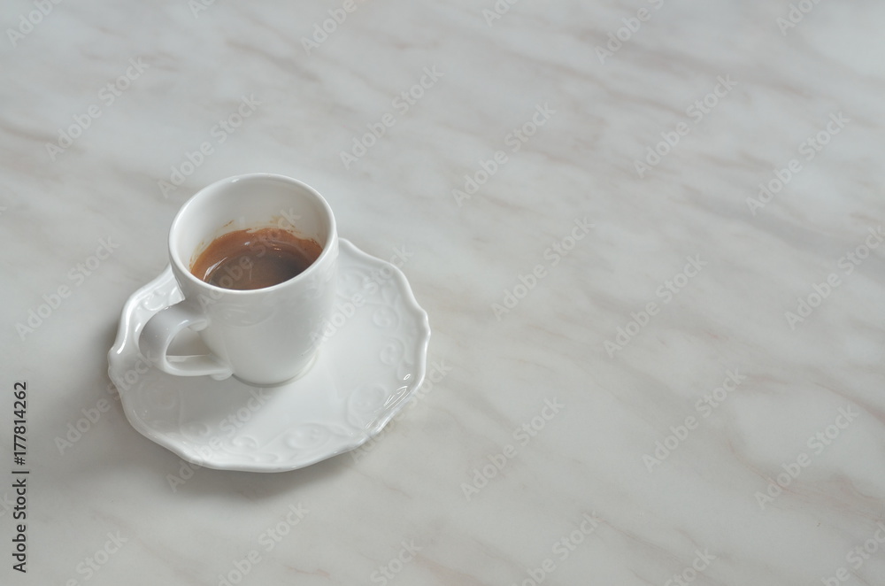 Cup Espresso (with a flower pattern on the surface) on White marble table.