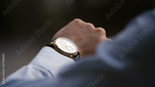 Young male business man is waiting for a meeting. Hand with a clock close up. Waits. Looks at the clock, time.