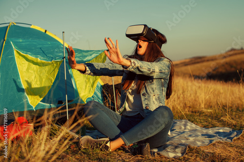 Young woman have fun with VR Headset BOX at camping