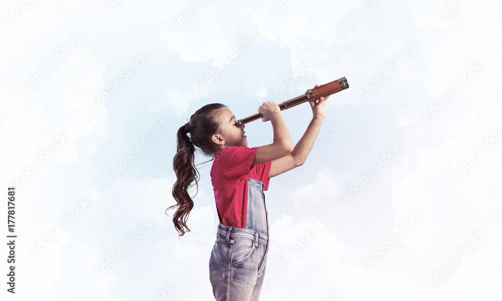 Concept of careless happy childhood with girl looking in spygl Concept of careless happy childhood with girl looking in spygl