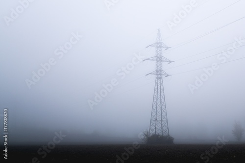 Electricity pylon and the wires against in the mist