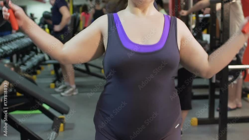 Obese woman training in the gym and jumping rope, fitness, weightloss workout Obese woman training in the gym and jumping rope, fitness, weightloss workout