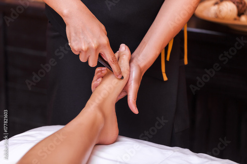 reflexology thai foot massage, spa foot treatment by wood stick,Thailand photo