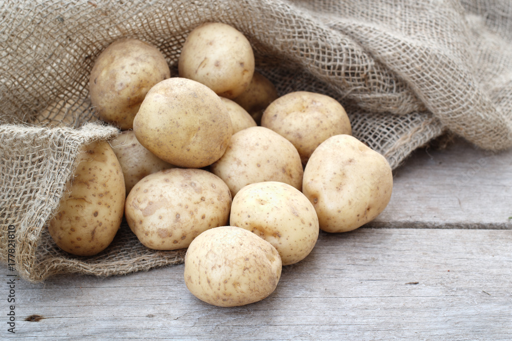 Potatoes spilled out of burlap sack. Potatoes spilled out of burlap sack.