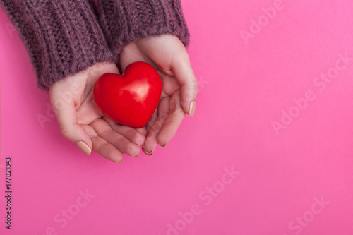 Fototapeta Naklejka Na Ścianę i Meble -  People, relationship and love concept - close up of womans cupped hands showing red heart