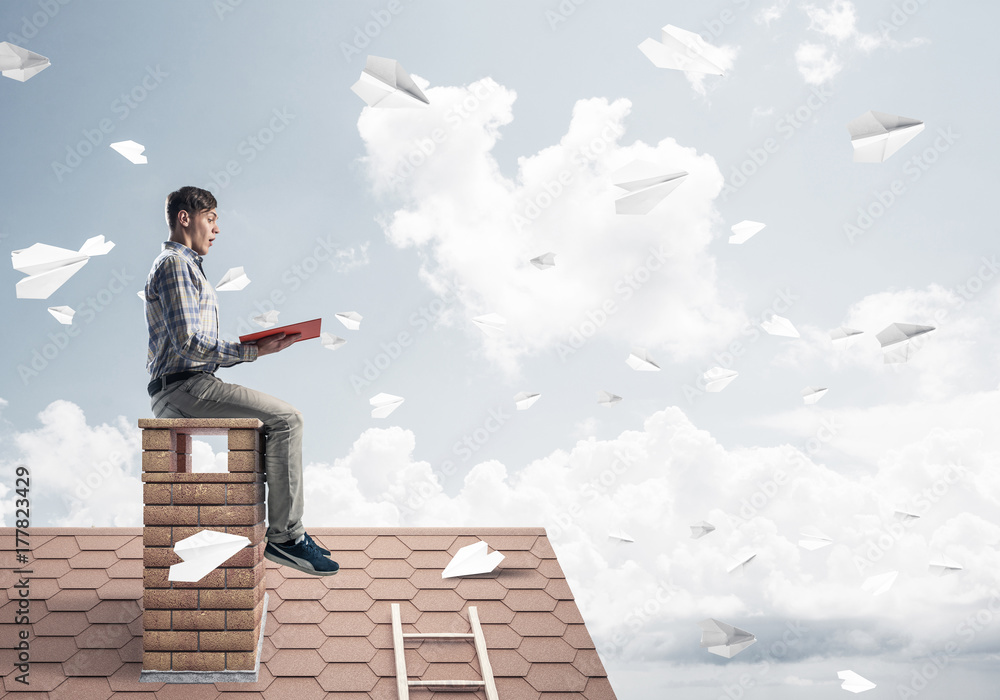 Handsome student guy reading book and paper planes flying in air Handsome student guy reading book and paper planes flying in air