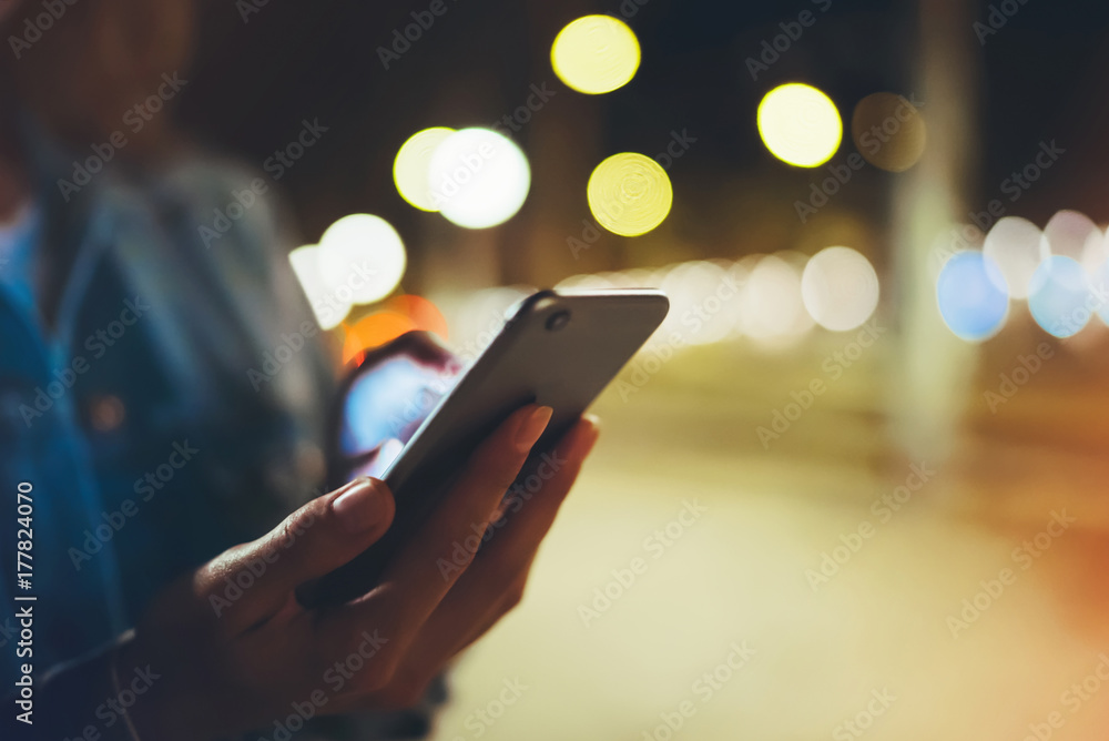 Woman pointing finger on screen smartphone on background illumination bokeh light in night atmospheric city, hipster using in hands mobile phone closeup, glitter street, online wifi internet concept Woman pointing finger on screen smartphone on background illumination bokeh light in night atmospheric city, hipster using in hands mobile phone closeup, glitter street, online wifi internet concept