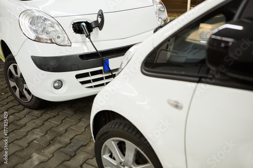 Electric car charged on a charging station in a indoor parking of shopping center by night.  © scharfsinn86