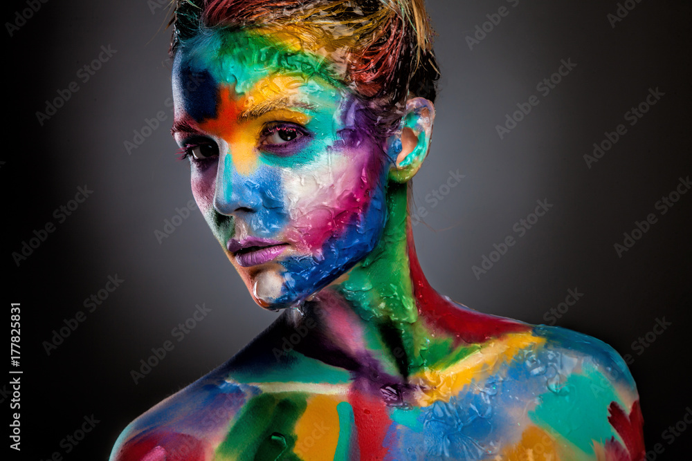 Fashion model girl portrait with colorful paint make up. Sexy woman bright color makeup. Art design. Grey background