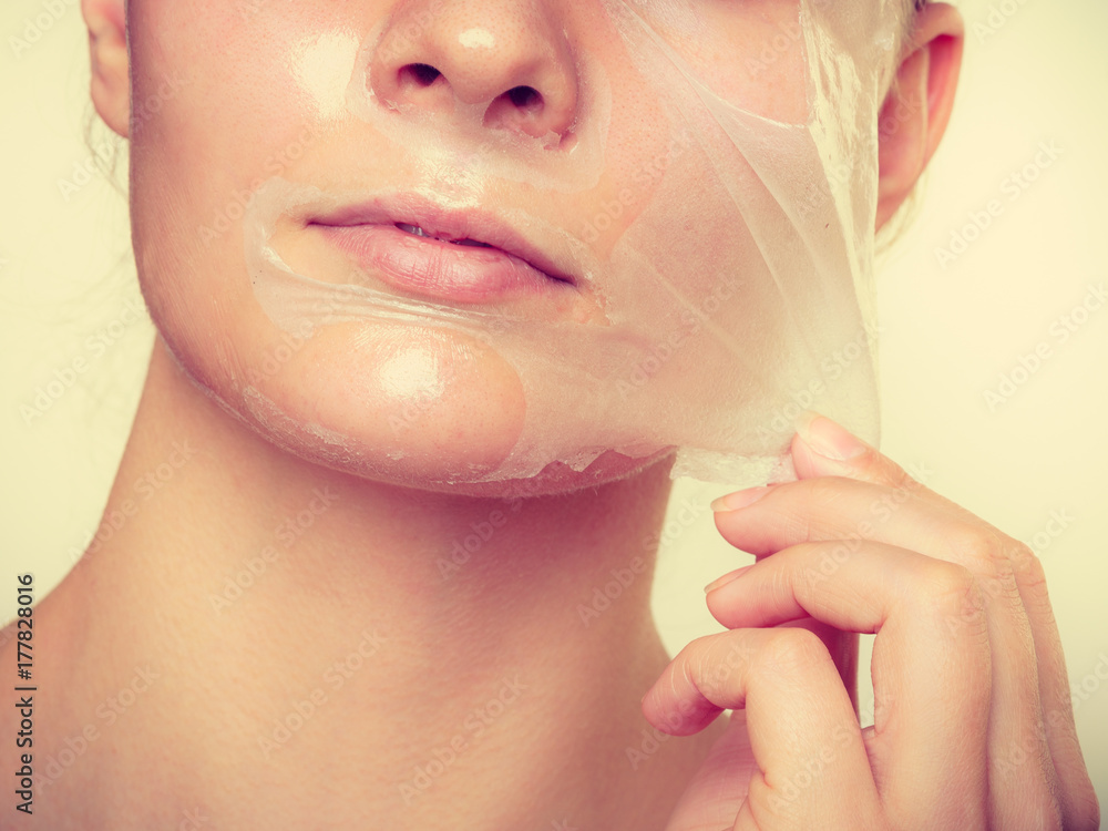 Woman removing facial peel off mask. Woman removing facial peel off mask.