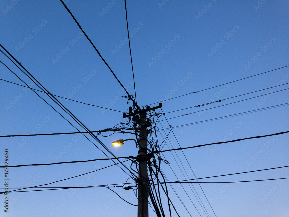 © BrkatiKrokodil/Stocksy - Transmission line post at dusk © BrkatiKrokodil/Stocksy - Transmission line post at dusk