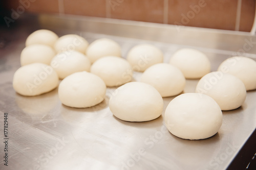 Φωτογραφία pizza dough round lies in a row, blanks for cooking oven