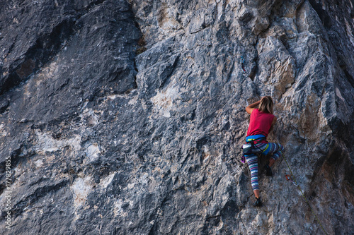 The girl climbs the rock.