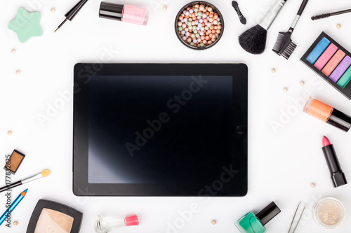 set of professional decorative cosmetics and makeup tools with tablet on white background with copy space for text. beauty, fashion, party and shopping concept. flat lay frame composition, top view