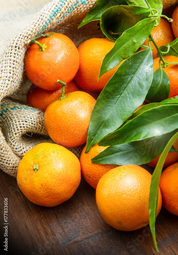 fresh mandarin oranges fruit with leaves on wooden table