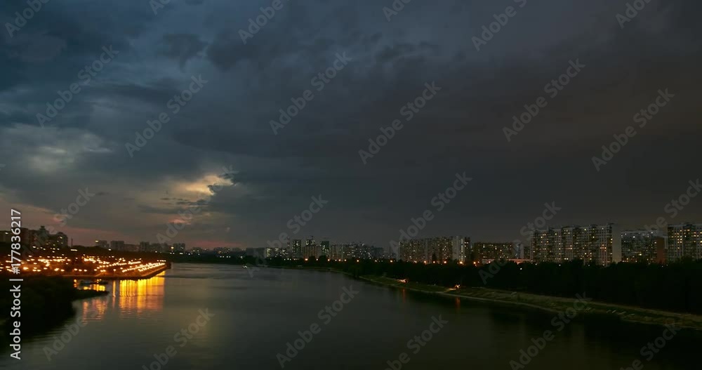 Time lapse cityscape of tour boat traffic on river and the movement of the thunderstorm front at dusk. Apartments buildings at background. Time lapse cityscape of tour boat traffic on river and the movement of the thunderstorm front at dusk. Apartments buildings at background.