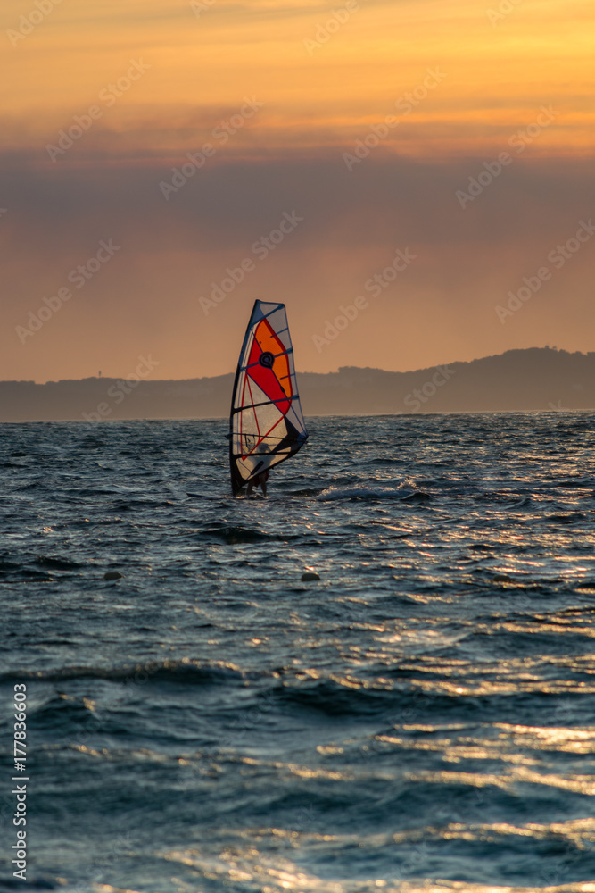 Naklejka premium Sunset over the sea or ocean and extreme freestyle sport windsurfing