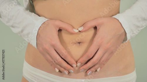 Wallpaper Mural A pregnant woman shows heart shape out of their hands. Slow motion Torontodigital.ca