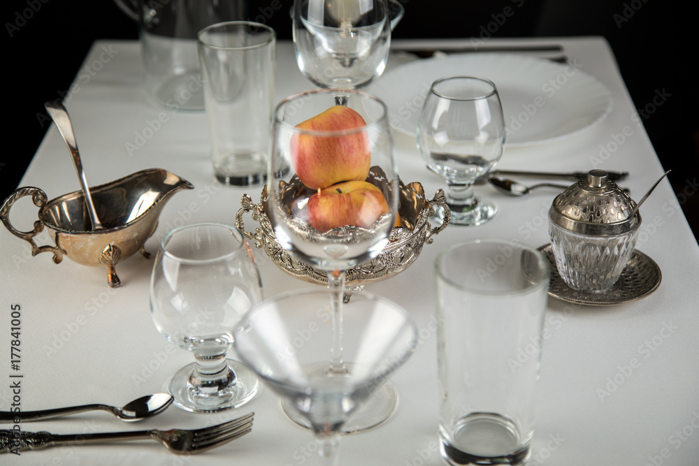 Fototapeta premium apples on a festive table with glasses and cutlery