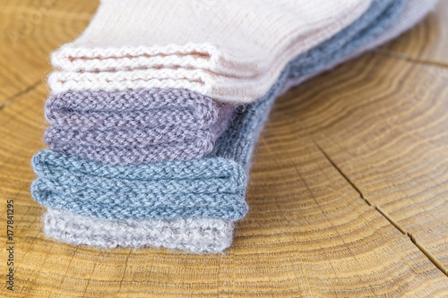 Set of cute small different colored cashmere knitted newborn baby socks on a wooden desk background