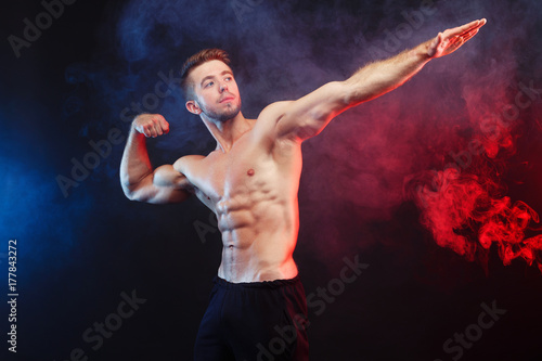 Young handsome muscular fit man bodybuilder demonstrating perfect trained body. Power, strength, excellent body, bodybuilding, sports concept