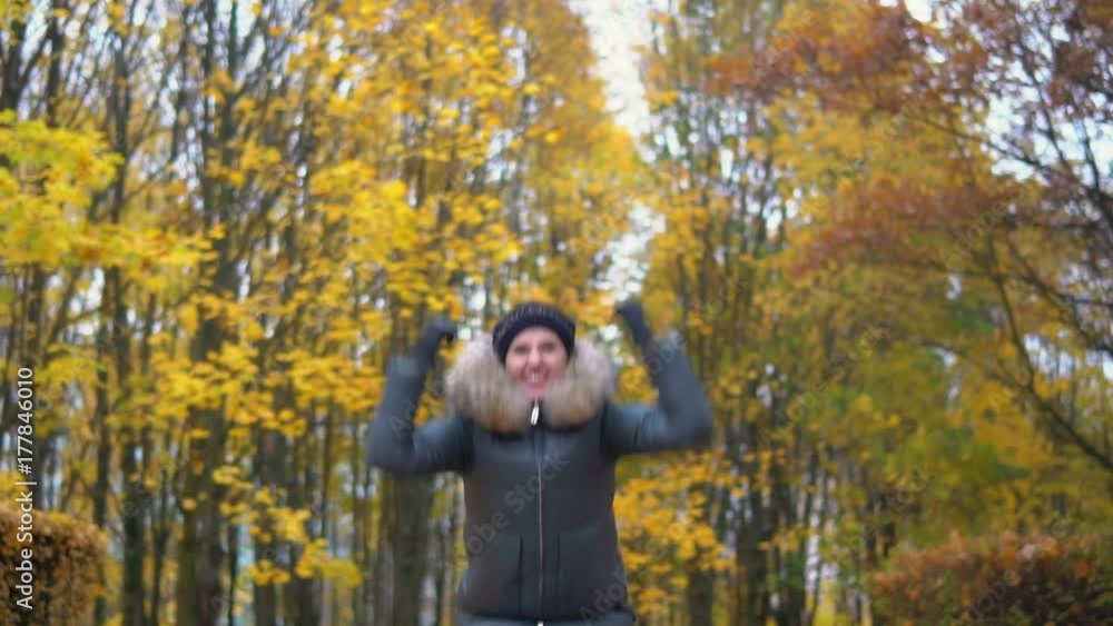 A woman is dancing in an autumn park A woman is dancing in an autumn park