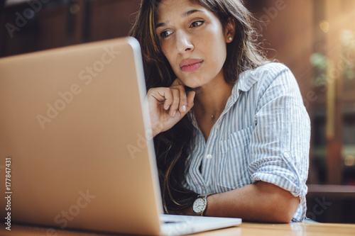 Smiling business woman sitting at her office and using lapto