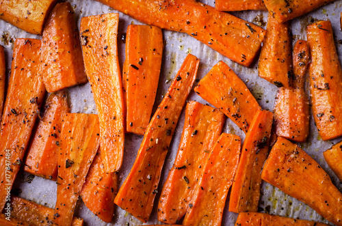 Roasted Caramelized organic Carrots with spices on black tray