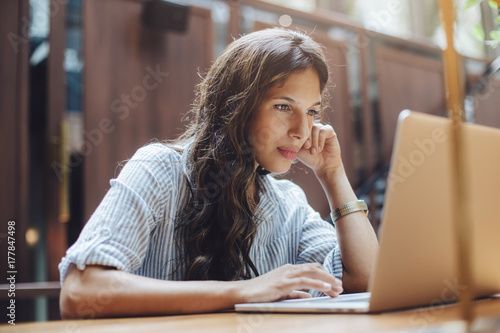 Close-up image of young professional female manager using laptop at her office