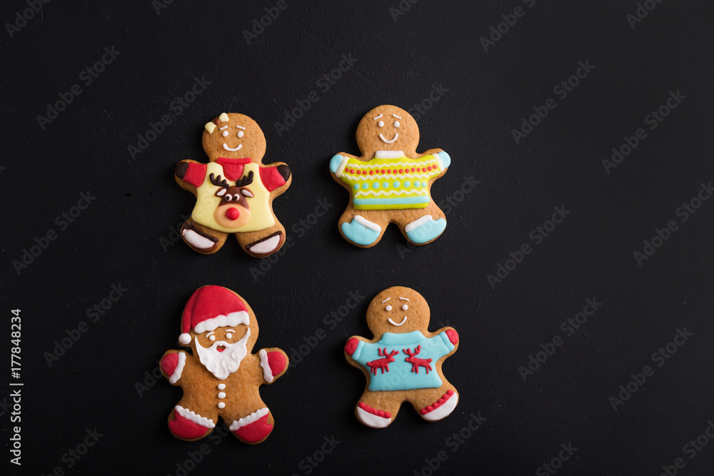  Ginger men with colored  glaze on a black background . Gingerbread. Christmas cookies.