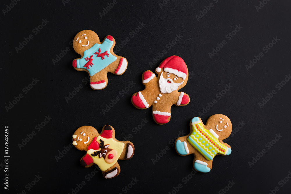  Ginger men with colored  glaze on a black background . Gingerbread. Christmas cookies.