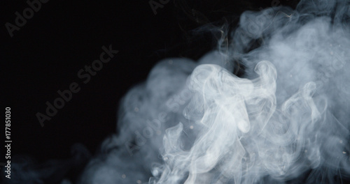 Thick billowing clouds of smoke over dark background