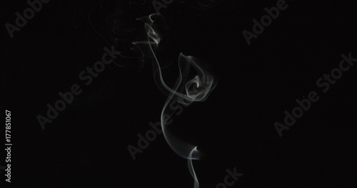 Tiny trail of smoke over dark background