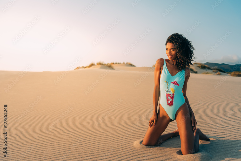 Beautiful young woman posing on the sand in a desert dunes Beautiful young woman posing on the sand in a desert dunes
