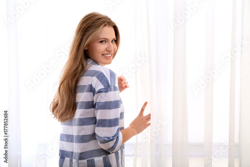 Young beautiful woman relaxing near window at home