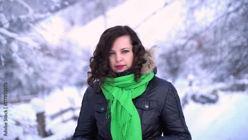 Young beautiful girl in winter forest looking at camera. The girl is pensive. Close-up. Young beautiful girl in winter forest looking at camera. The girl is pensive. Close-up.