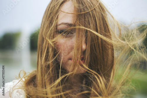 Portrait of a beautiful young woman with hair blown by wind photo