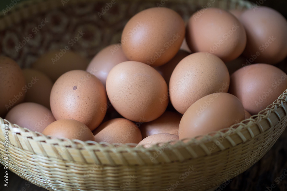 Close up of eggs in a basket on wooden table background Close up of eggs in a basket on wooden table background