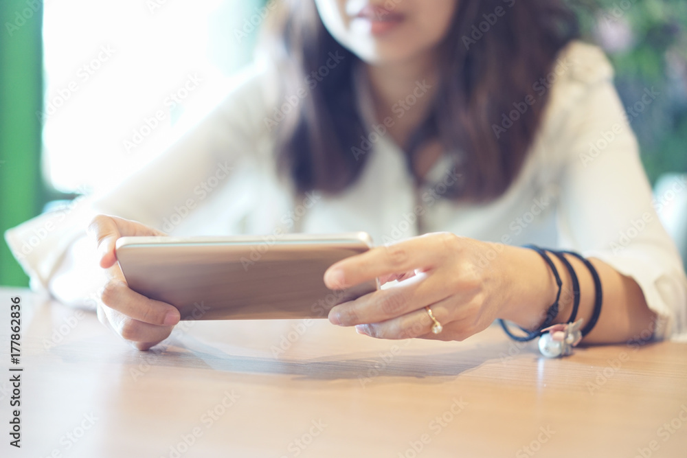 Women's hands holding smartphone in coffee shop place Women's hands holding smartphone in coffee shop place