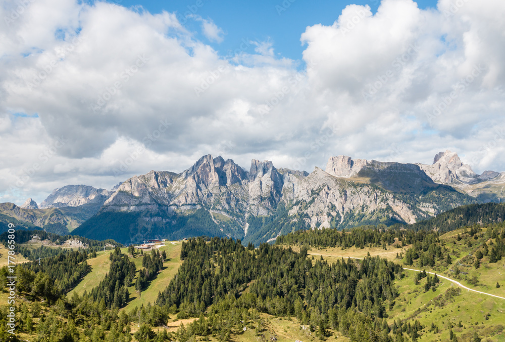 panoramic view of mountain ranges in Dolomites with cloudy sky and copy space