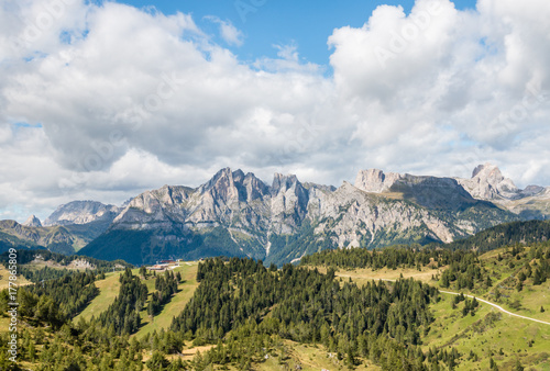 panoramic view of mountain ranges in Dolomites with cloudy sky and copy space