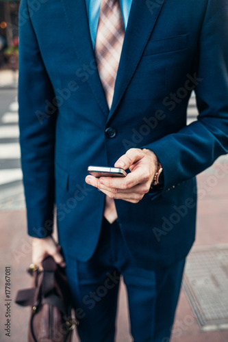 Modern Caucasian Businessman Texting on the Street photo