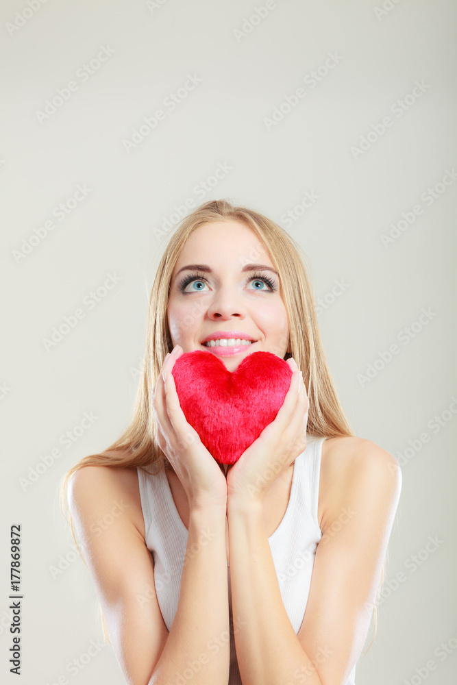 Smiling woman holding red heart love symbol Smiling woman holding red heart love symbol