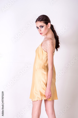 Girl in nightgown stand on white background