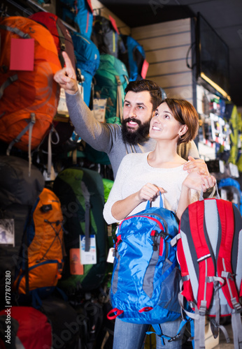Couple choosing rucksack in store