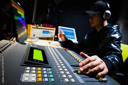 asian male sound engineer working in digital audio & video editing post production studio photo