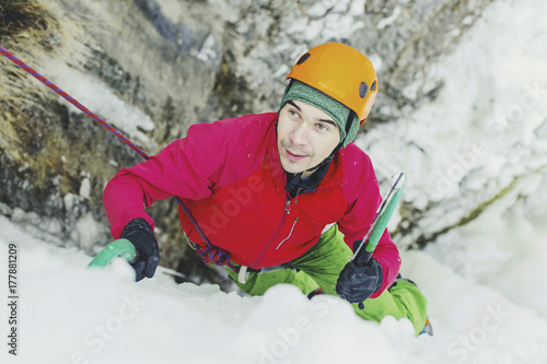 Ice climbing in the mountains along the waterfall.